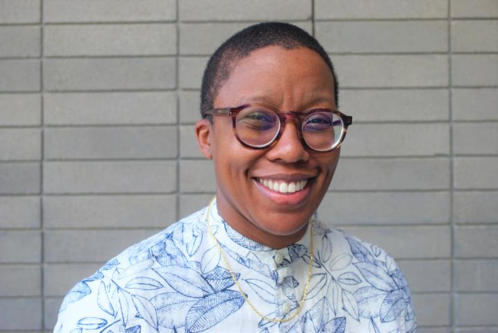 Donika Kelly smiles, wearing a white shirt printed with blue leaves