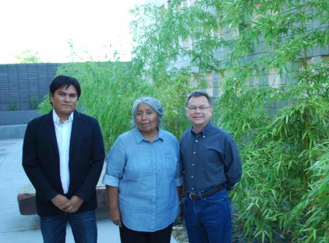 Sherwin Bitsui in a black jacket, Ofelia Zepeda in a light blue shirt, and Alberto Ríos in a dark blue shirt pose in front of bamboo shoots.